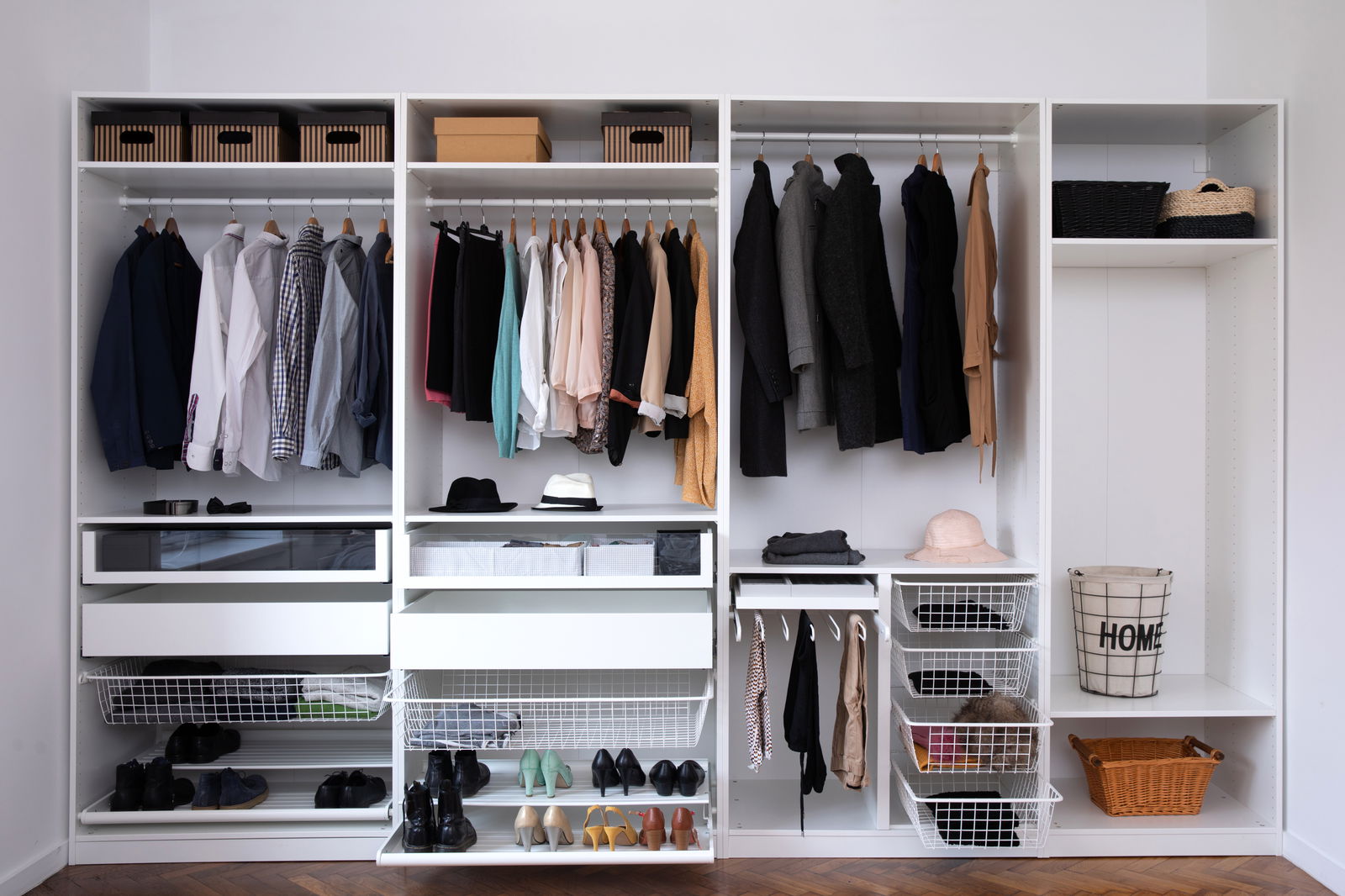 Neat open closet system with shelves, hanging rods, baskets, and organized clothing, shoes, and accessories.