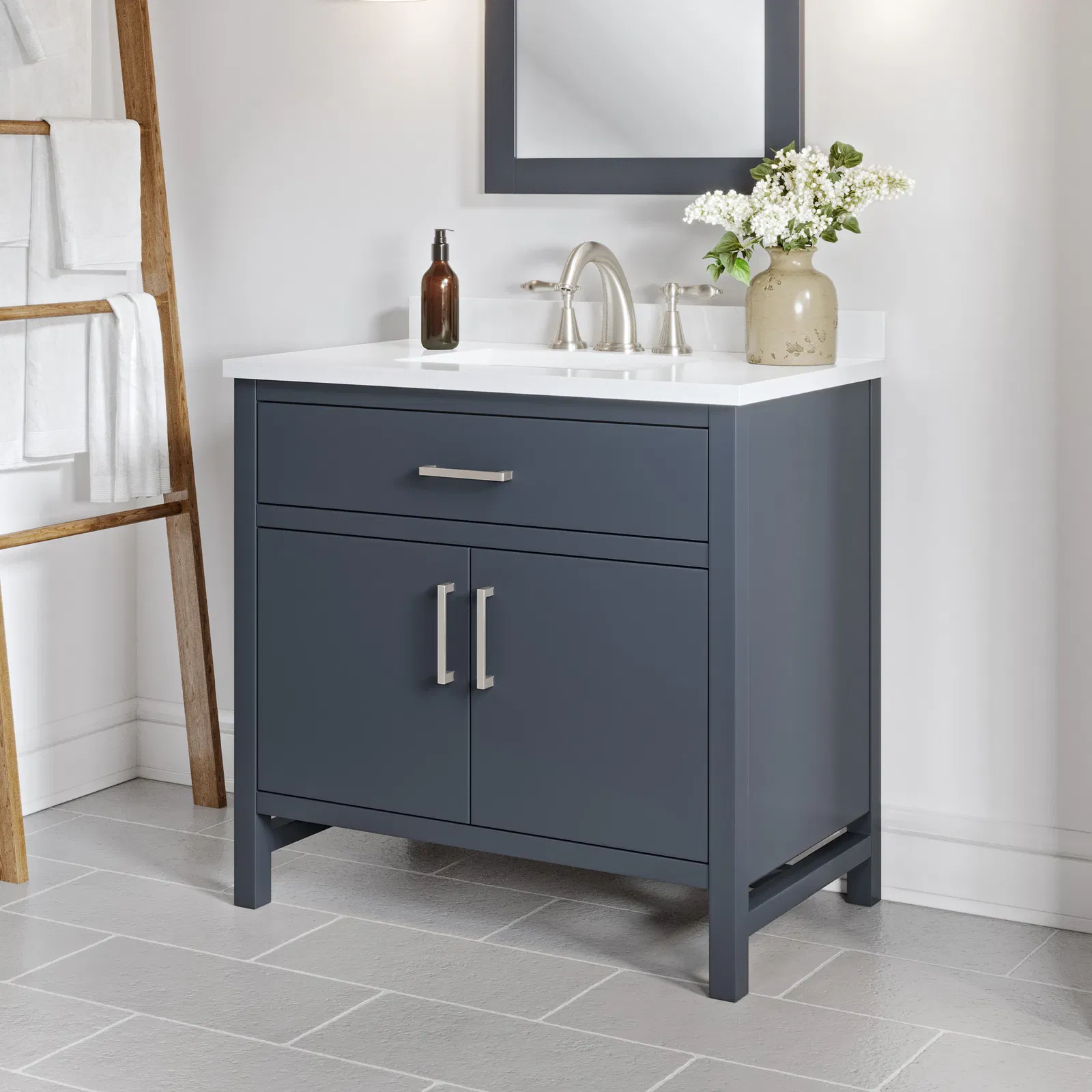 Modern navy blue bathroom vanity with white countertop and brushed nickel hardware
