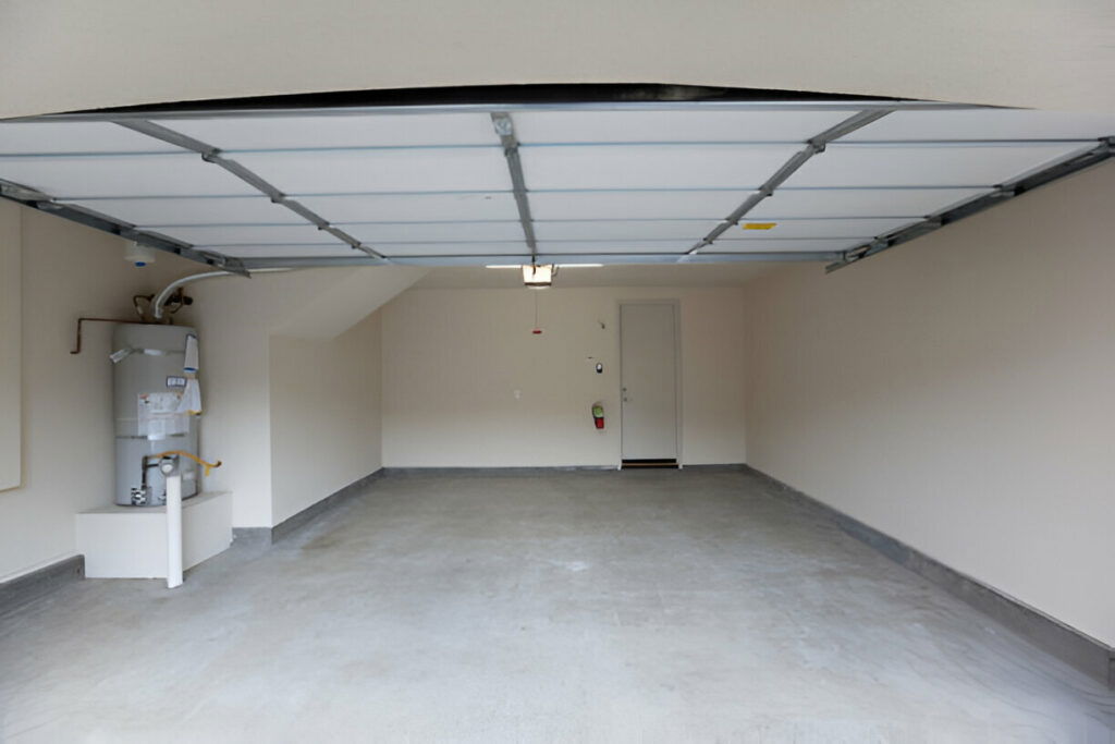 20 Inspiring Small Garage Conversion Ideas 9 Empty residential garage with open door and air conditioner on the left side.