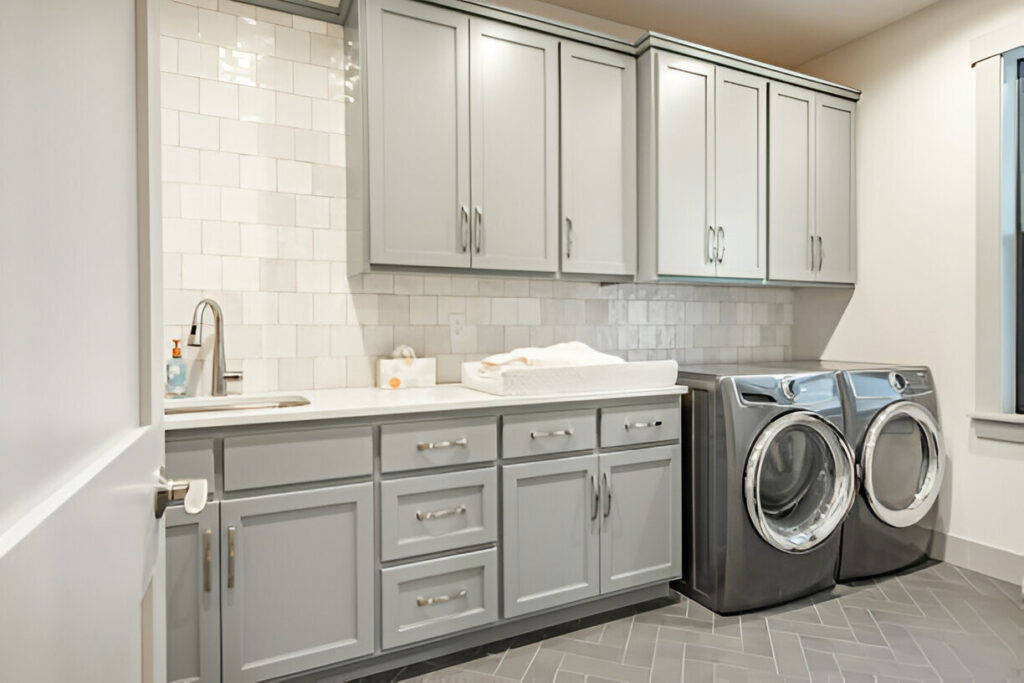 20 Inspiring Small Garage Conversion Ideas 23 Modern laundry room with gray cabinets, a countertop with a built-in sink, and a matching washer and dryer set