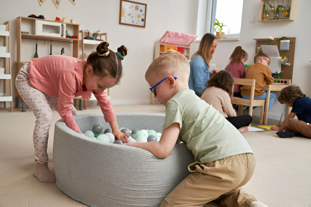 20 Inspiring Small Garage Conversion Ideas 27 Children playing in a bright, modern playroom filled with educational toys, creative art stations, and a soft ball pit. The room features light wood furniture, cheerful decorations, and plenty of space for creative activities