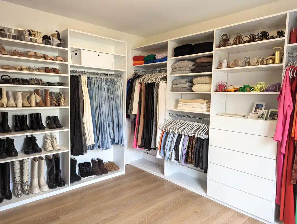 Custom Closet Systems Personalized Guide 14 A modern walk-in closet featuring white custom shelving, built-in drawers, dedicated shoe storage, and organized hanging space for a stylish and functional wardrobe.