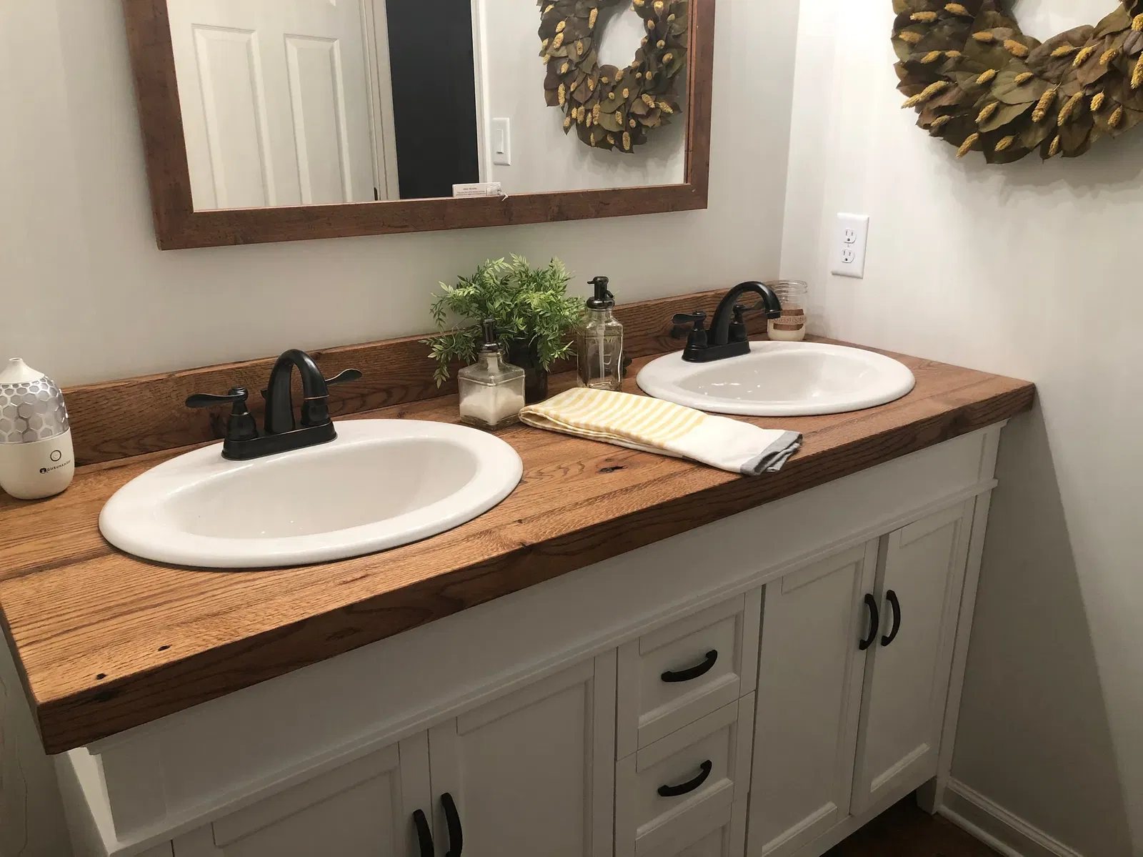 Rustic double sink bathroom vanity with wood countertop and white base cabinet