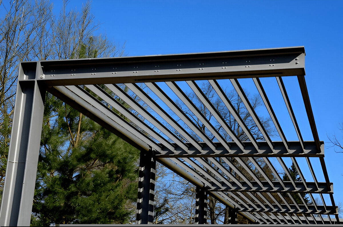 Close-up of a modern steel pergola with horizontal slats against a clear blue sky