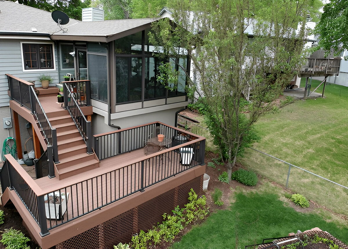 Glass sunroom extension with elevated composite deck and staircase