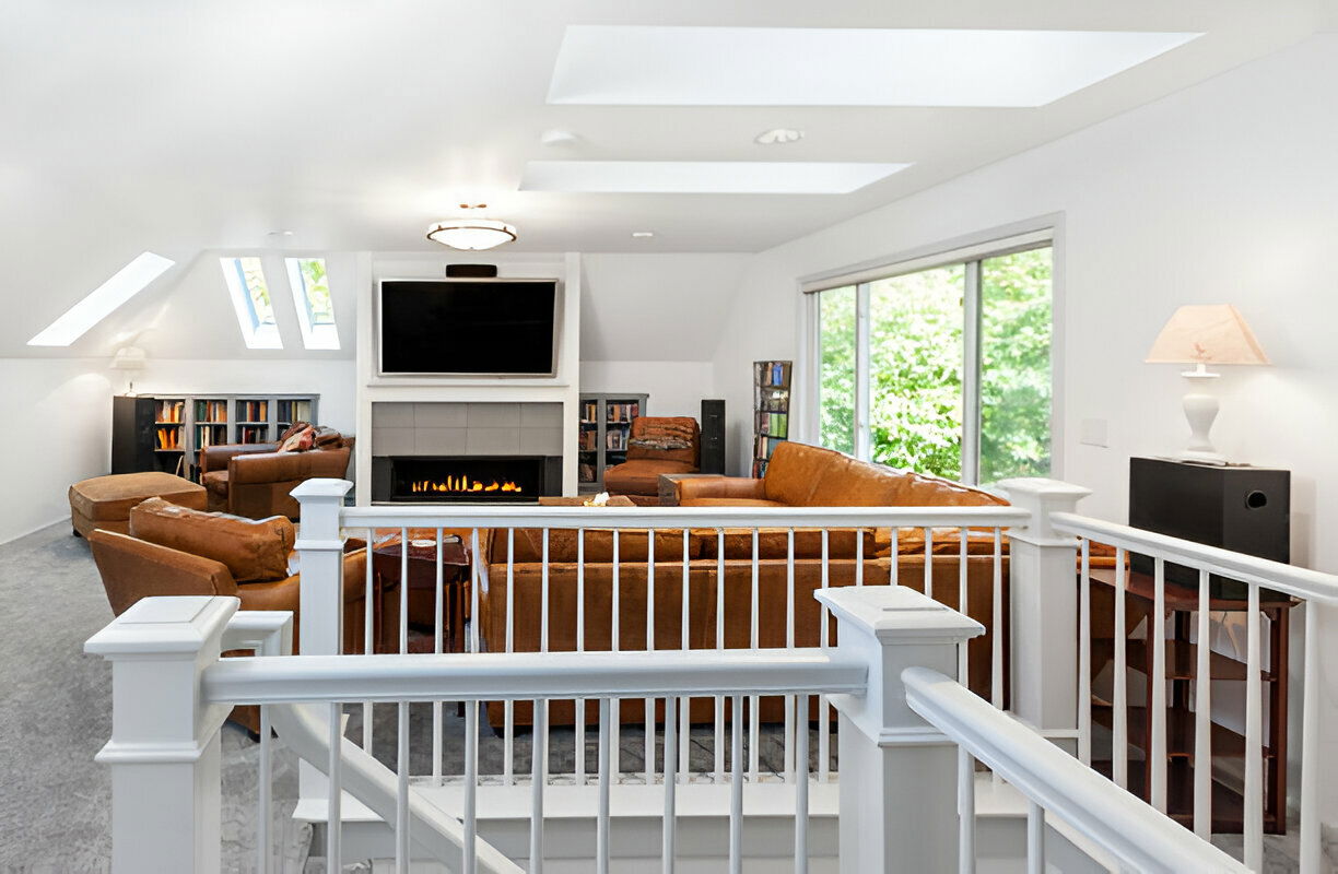 Modern upstairs living room with fireplace and skylights. 