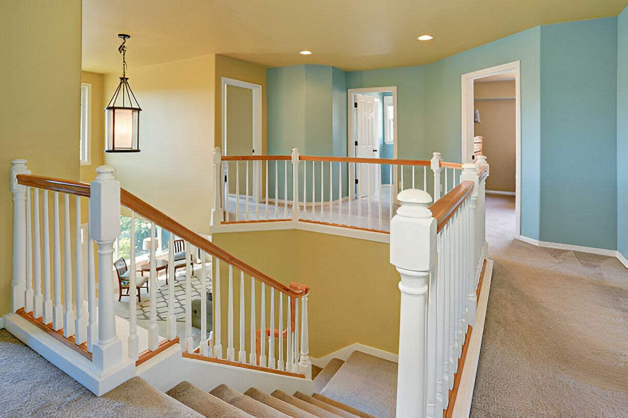 Second floor hallway with white railing and carpet