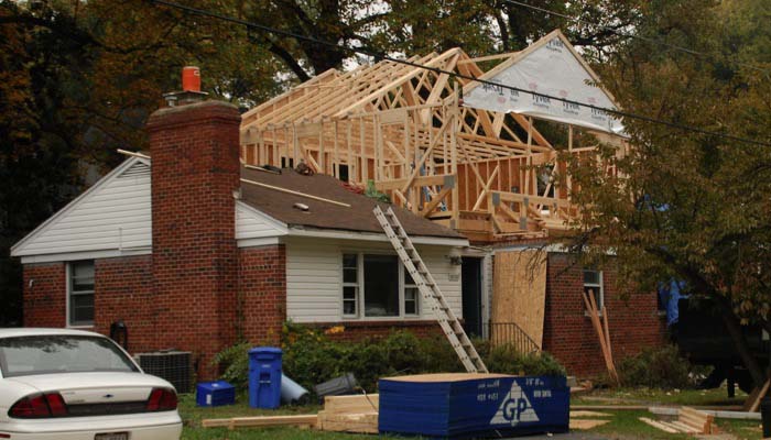 Second floor home addition under construction on a brick house. 