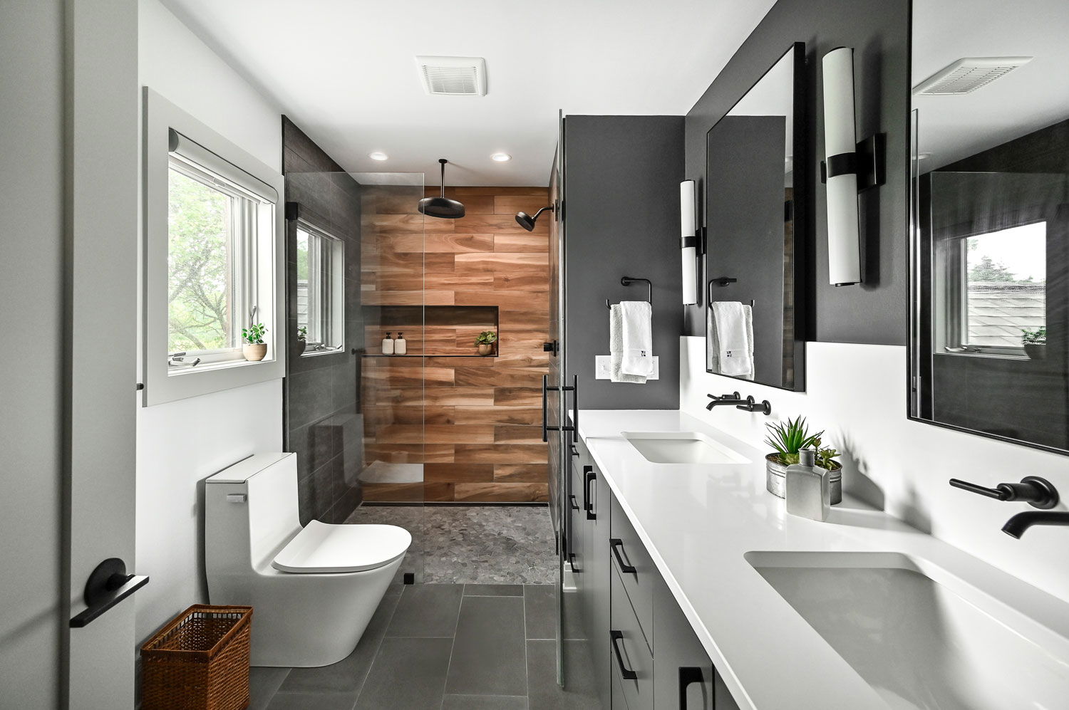 Modern bathroom with wood-look shower wall, matte black fixtures, double vanity, and minimalist design.
