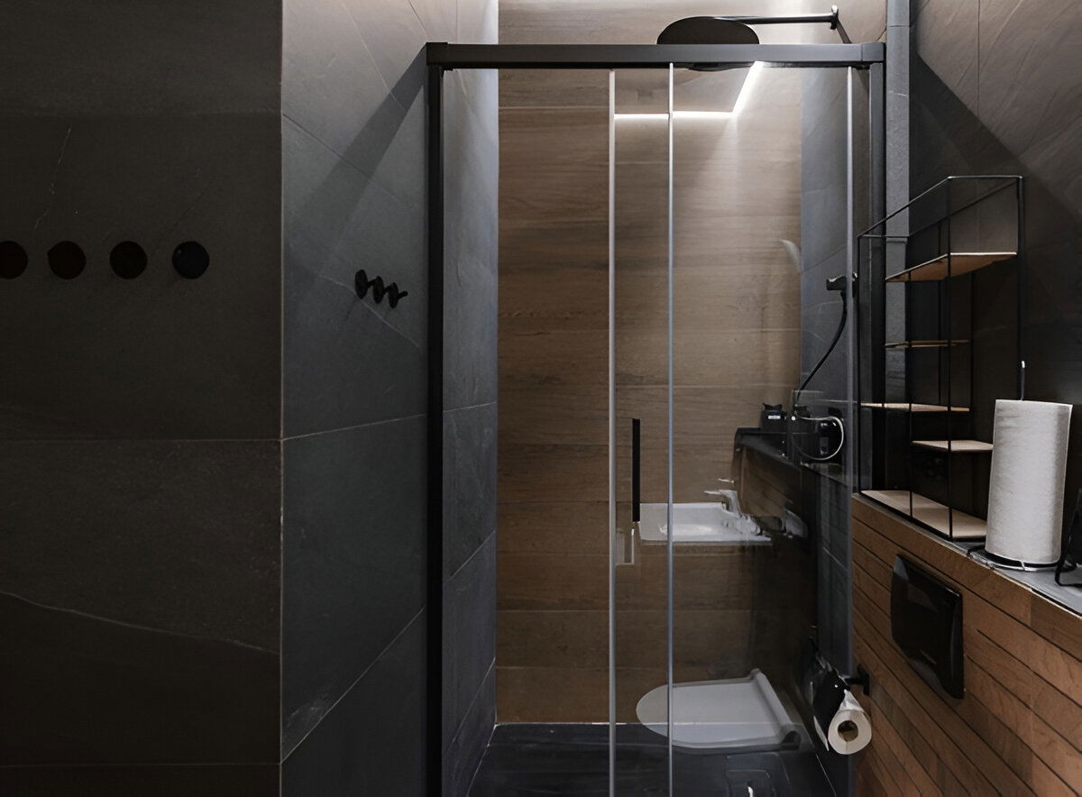 Minimalist bathroom with glass shower enclosure and wood accents