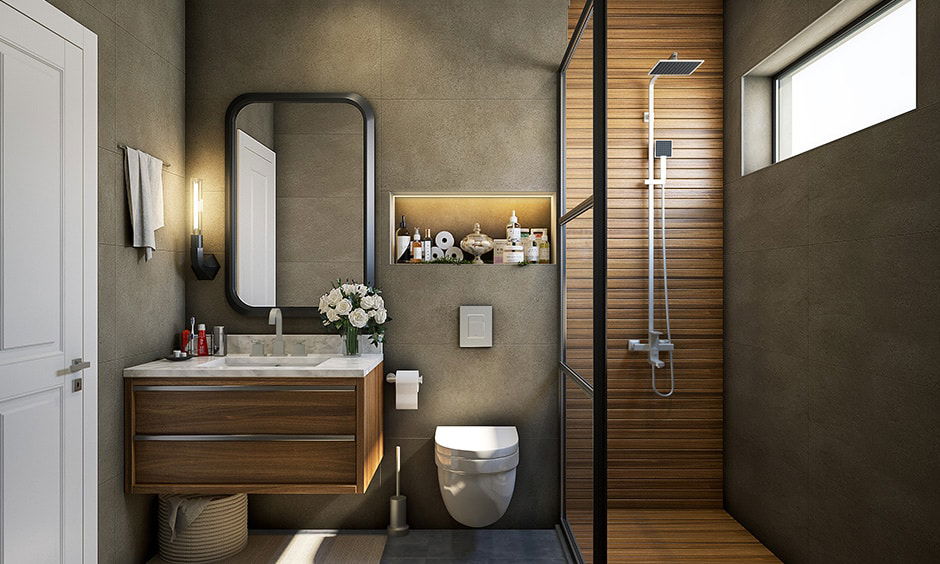 Contemporary small bathroom featuring a wood vanity, wall-mounted toilet, glass-enclosed shower, and built-in shelf with lighting
