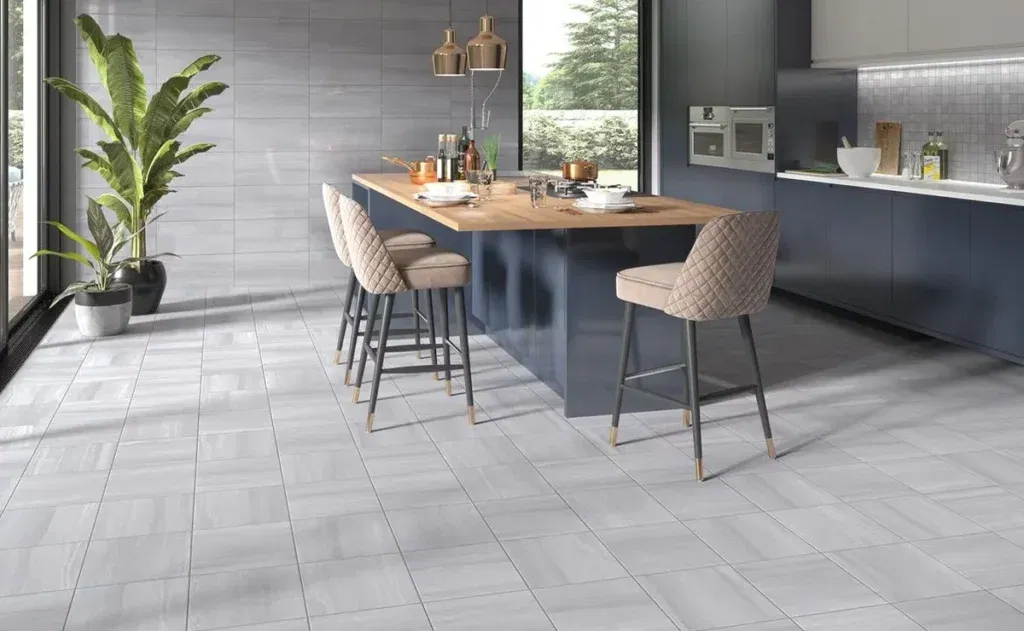 Contemporary kitchen with light gray ceramic tile flooring, navy cabinets, wooden island, and bar stools