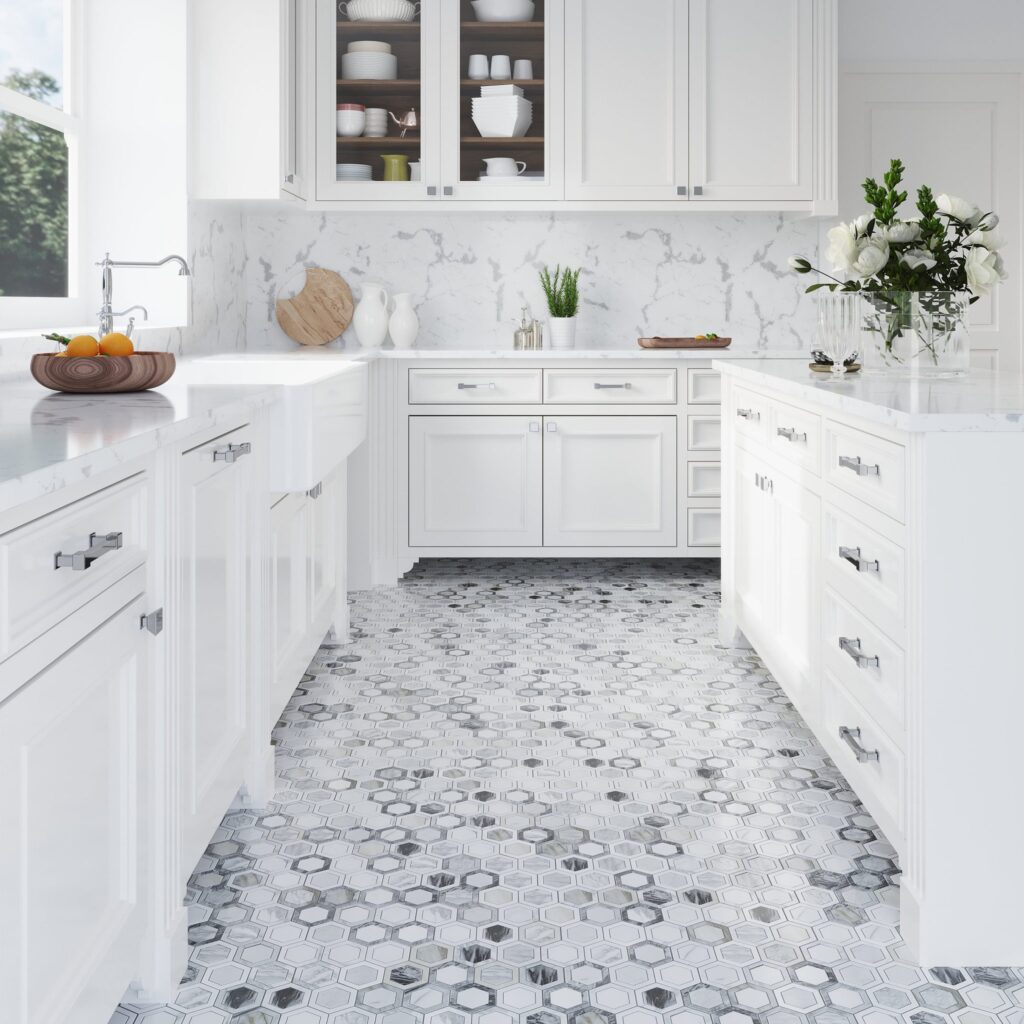 Bright white kitchen with marble countertops, white cabinetry, and decorative hexagon marble tile flooring.