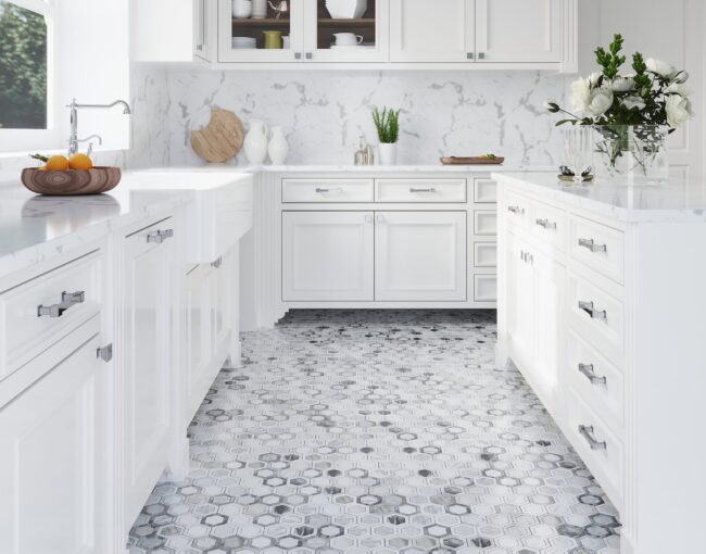 Bright white kitchen with marble countertops, hexagon-pattern marble tile flooring, and classic cabinetry.