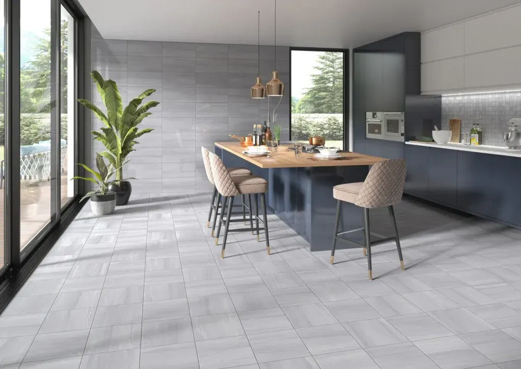 Contemporary kitchen interior featuring light gray ceramic floor tiles, a navy blue island with wooden countertop, and elegant beige bar stools