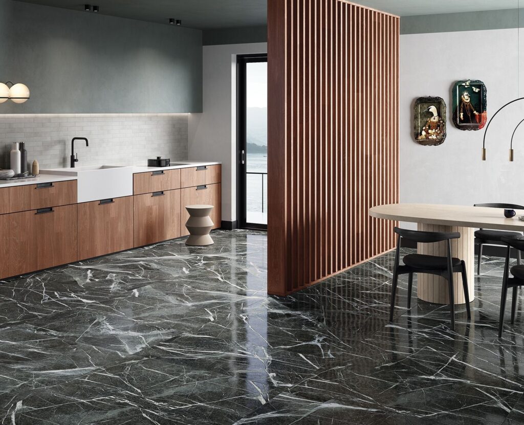 Stylish modern kitchen with dark marble flooring, minimalist wooden cabinetry, a farmhouse sink, and a contemporary dining area with a slatted wood room divider