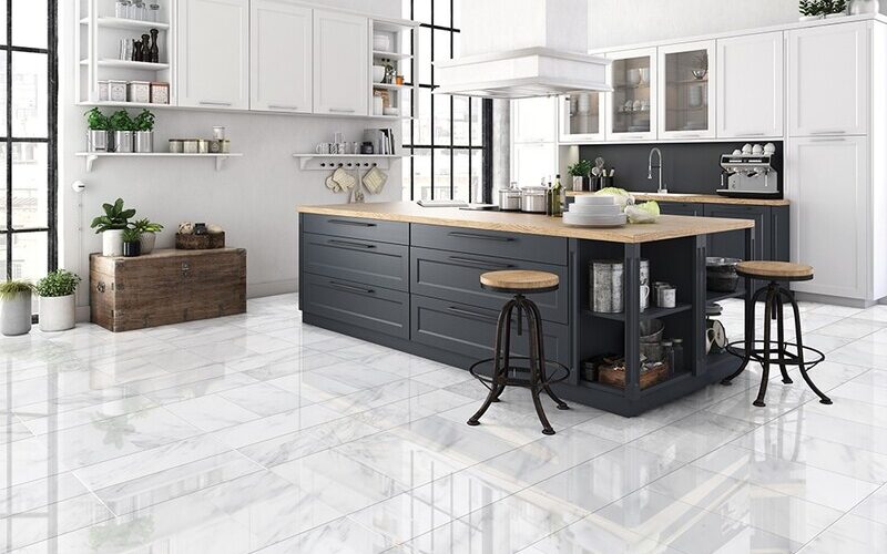 Contemporary kitchen with white and navy cabinets, glossy marble floor tiles, wooden countertops, and industrial-style bar stools