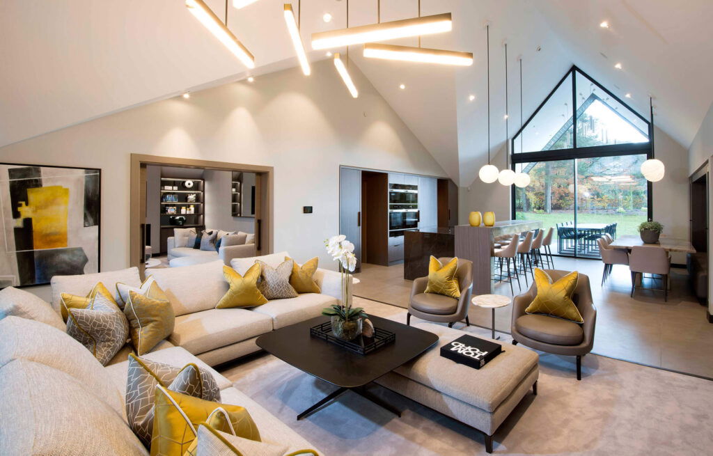 Modern open-concept living and dining space with vaulted ceiling, large windows, and elegant decor.