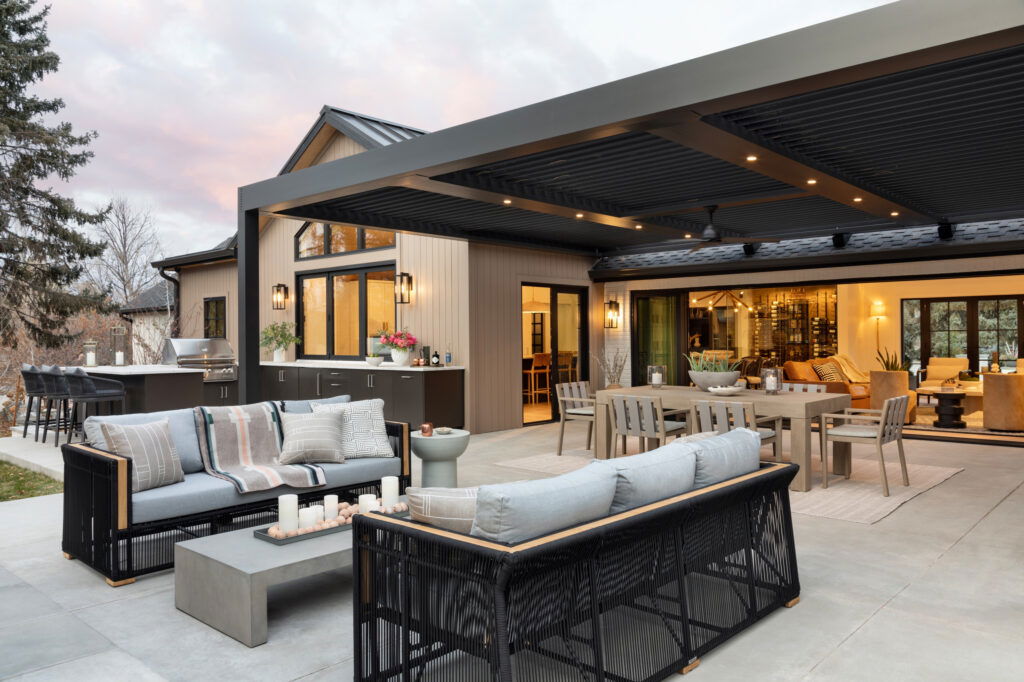 Stylish covered patio with modern outdoor kitchen, dining area, and lounge seating.