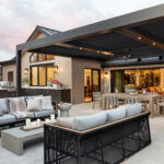 Stylish covered patio with modern outdoor kitchen, dining area, and lounge seating.
